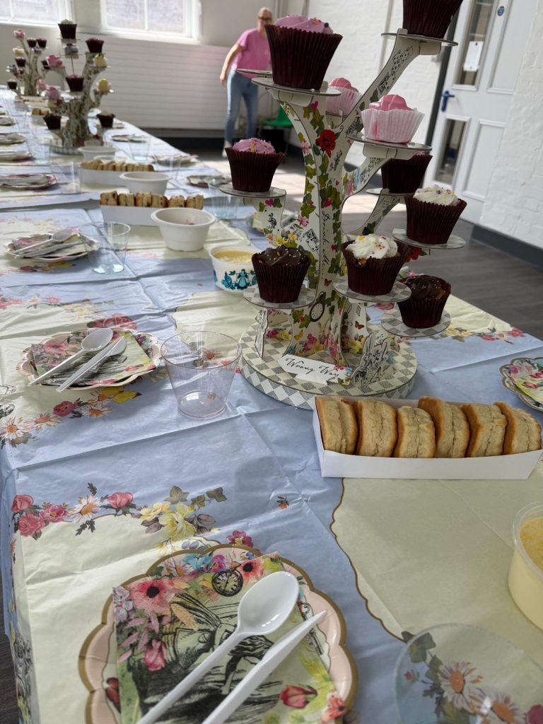 Afternoon tea all set up on the table, with scones, cup cakes and drinks